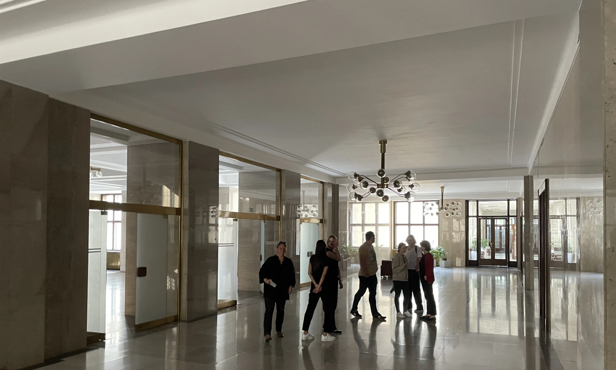 A couple of people walking in the hall of the town-hall